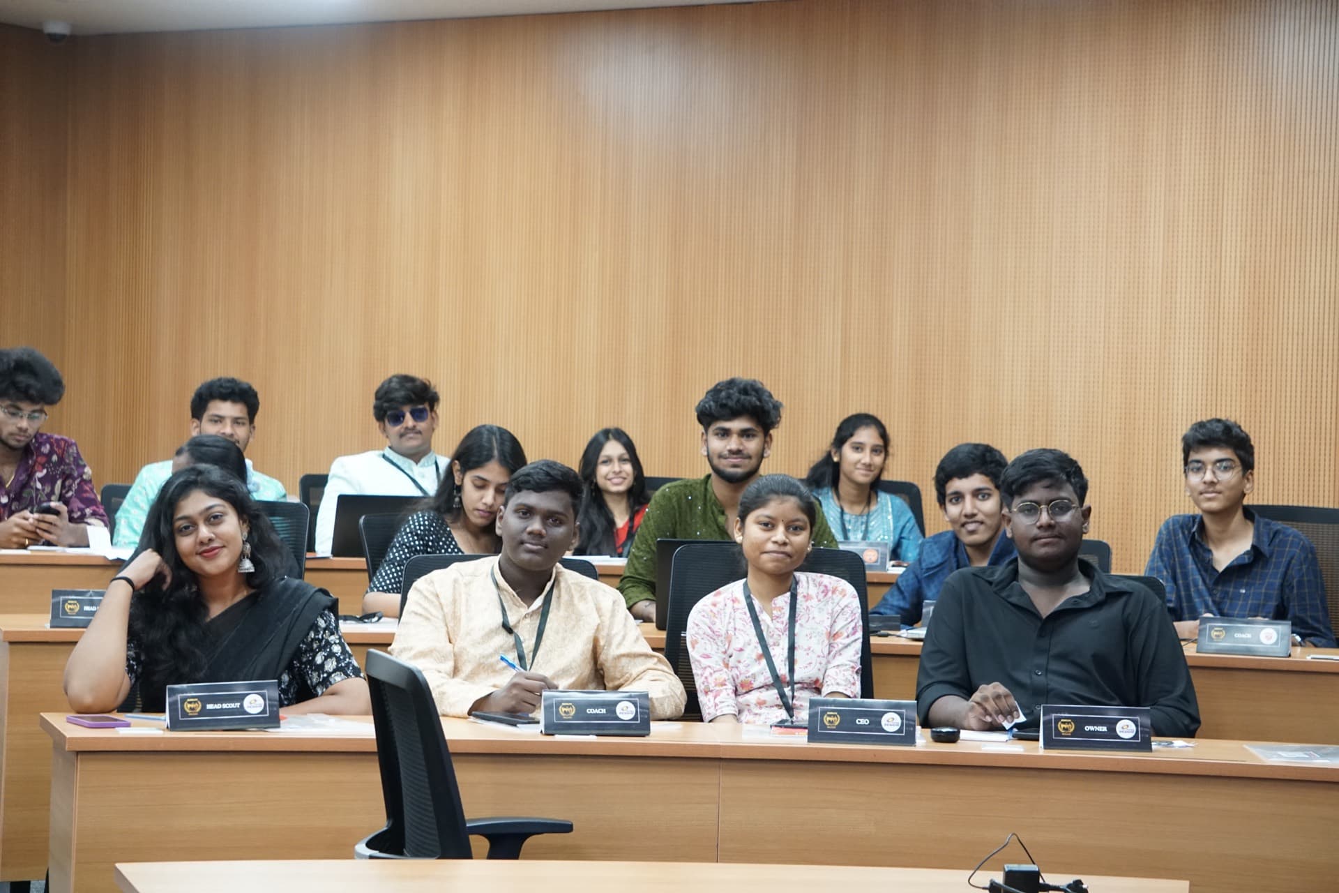 A committee of GMUN delegates smiling at their desks